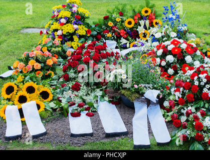 Blumen und Grab in einem alten Friedhof Stockfoto