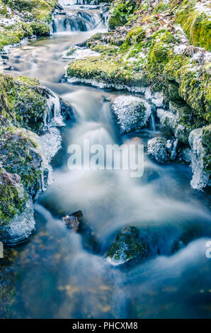 Strömung von Wasser im Frühjahr Eiszapfen und Eis Stockfoto