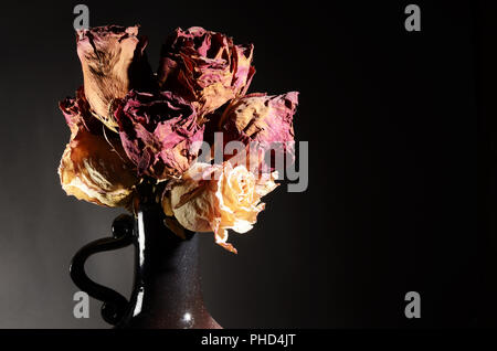 Bouquet von getrockneten Rosen in Keramikvase Stockfoto