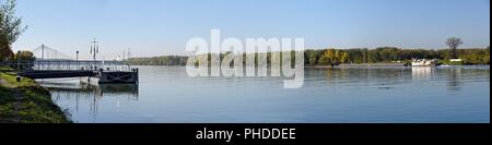 Blaue Donau mit Schiffsanlegestelle Stockfoto