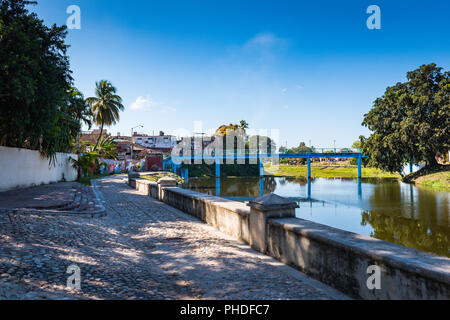 Sancti Spiritus, Kuba/15. März 2017: gepflasterten Gehweg und Wandbild entlang der Yayabo River. Stockfoto