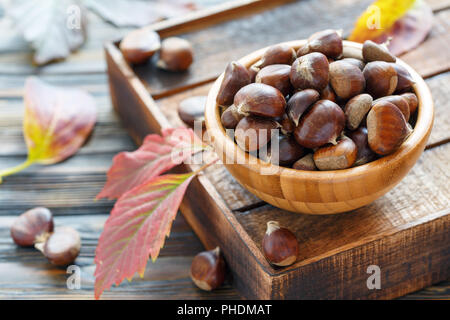 Reife Kastanien in eine hölzerne Schüssel. Stockfoto