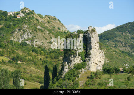 Das mittelalterliche Dorf Barret de Lioure mit Blick auf einen großen Kalkstein-butte. Montbrun-les-Bains, Drôme, Auvergne-Rhône-Alpes, Frankreich. Stockfoto
