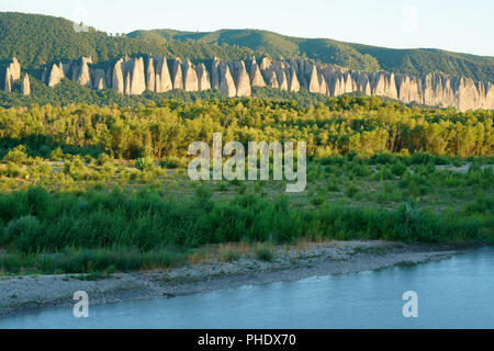 Längliche Felsformation aus Pfützerstein, genannt "die Penitents", zwischen dem Plateau der Valensole und dem Fluss Durance. Les Mées, Provence, Frankreich. Stockfoto