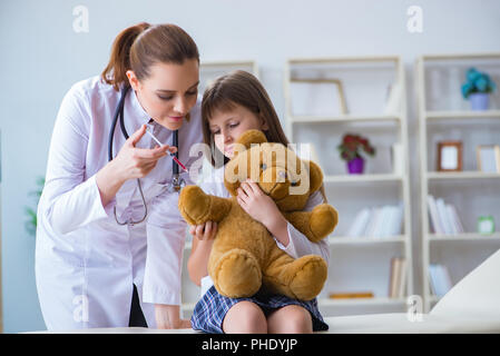 Frau Ärztin prüfung wenig nettes Mädchen mit Spielzeug tragen Stockfoto