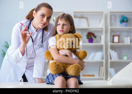 Frau Ärztin prüfung wenig nettes Mädchen mit Spielzeug tragen Stockfoto