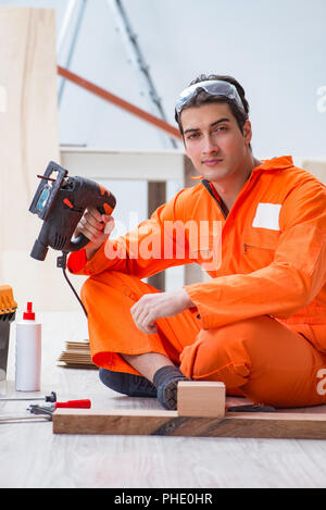 Auftragnehmer Arbeiten auf Laminat Holzboden Stockfoto