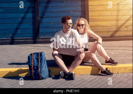 Paar in der Liebe mit einem Laptop durch die Stadt bummeln Stockfoto
