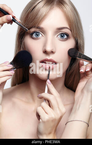 Blonde Schönheit weiblicher Stylist - visagist mit Make-up-Pinsel Stockfoto