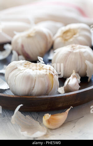 Knoblauch, Nelken und Peel auf einer hölzernen Schale. Stockfoto