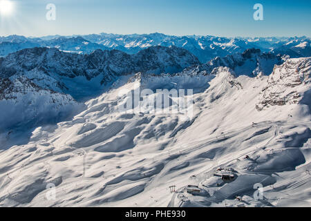 Ein Blick ins Tal vom höchsten Punkt Deutschlands, der Zugspitze. Der Blick geht über sterben sonnenbestrahlte Winterlandschaft im Wettersteingebirge. Stockfoto