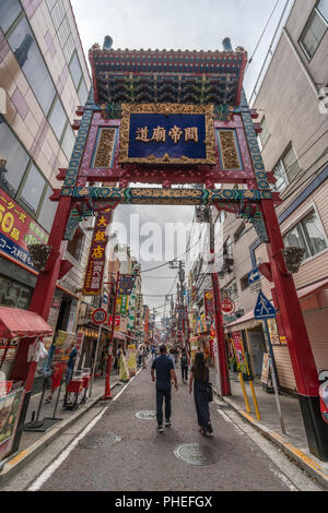 Menschen, die in Chinatown (ChukaGai) Japans größtem chinesischen Viertel spazieren gehen und genießen, voller Restaurants und farbenfroher Geschäfte Stockfoto