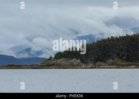 Am frühen Morgen auf den Lynn Canal in der Nähe von Juneau Alaska für ein Kreuzfahrtschiff Ausflug und humpback Whale Watching Tour classic Alaskan Landschaft und Wolken Stockfoto