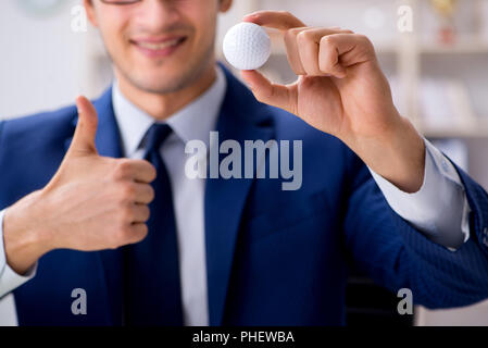 Junge Unternehmer mit Golf ball Arbeiten im Büro Stockfoto