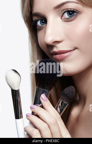 Blonde Schönheit weiblicher Stylist - visagist mit Make-up-Pinsel Stockfoto