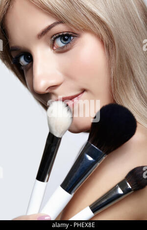 Blonde Schönheit weiblicher Stylist - visagist mit Make-up-Pinsel Stockfoto