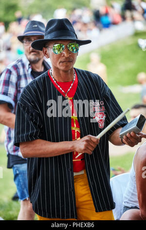 African American männlichen Schlagzeuger spielt Rhythmus mit einer Kuh Glocke an Tam Tams Festival in Mount Royal Park, Montreal, Quebec, Kanada. Stockfoto