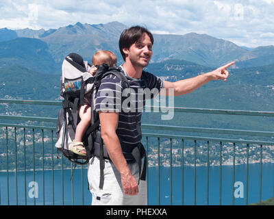 Vater mit Rucksack trägt Kinder während eines Ausflugs Stockfoto