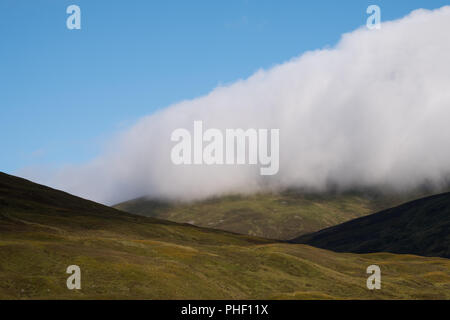 Blick auf die Hügel in den schottischen Highlands an einem klaren Sommer, mit Tiefliegenden cloud. In der Nähe von Inverness aus dem Caledonian Sleeper Zug fotografiert. Stockfoto