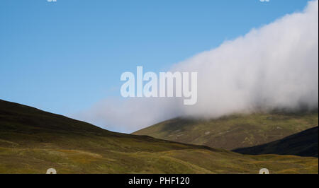 Blick auf die Hügel in den schottischen Highlands an einem klaren Sommer, mit Tiefliegenden cloud. In der Nähe von Inverness aus dem Caledonian Sleeper Zug fotografiert. Stockfoto