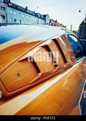 Zu sehen in der Nähe auf einem orange und schwarz Mustang in der Stadt Stockfoto