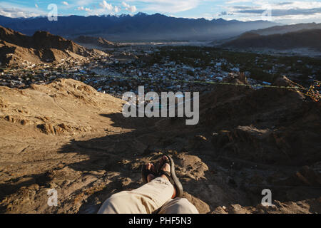 Reisen Stadt, in Leh in Ladakh, Indien. ein Mann sitzt auf einer Klippe mit Blick auf die Stadt leh am Morgen Stockfoto