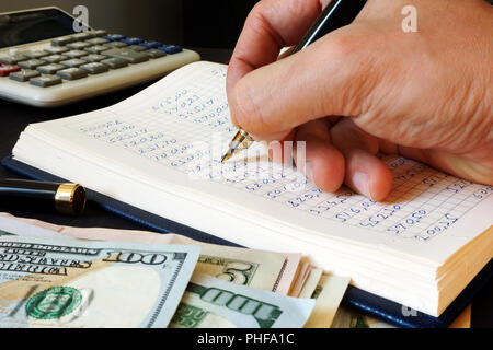 Buchhalter schreiben Finanzbericht in die Buchführung zu buchen. Stockfoto