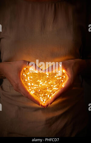 Frau mit Lichter in der Form eines Herzens Stockfoto