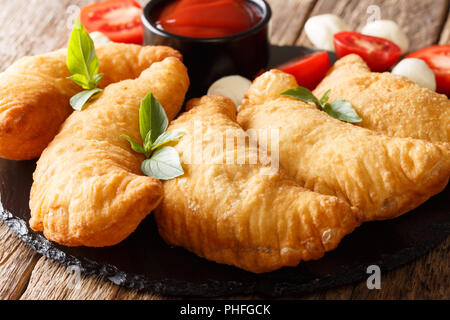 Italienische frittierte Krapfen panzerotti Close-up auf einem Holztisch. Horizontale Stockfoto