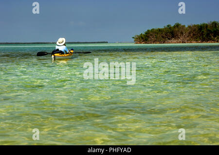 Ein kayaker Floating in türkis-grüne Wasser in den Florida Keys auf einem sonnigen blauen Himmel. Stockfoto