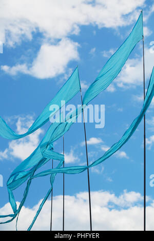 Blaue Flaggen im Wind singen gegen den blauen Himmel Stockfoto