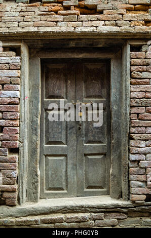 Alte Holztür - alten Holz Eingangstüre auf lehmziegeln Wand ruiniert Stockfoto