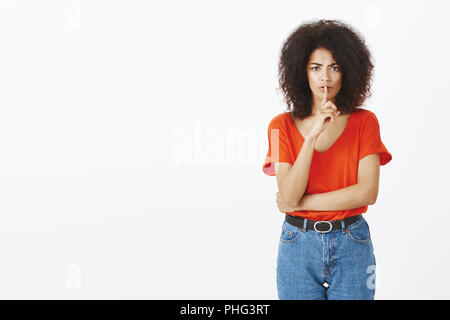 Shh, keine Unterhaltung. Unzufrieden unzufrieden Curly - behaarte Frauen mit dunkler Haut Hand gekreuzt und psst Geste mit dem Zeigefinger über Mund, die Stirn, mit der Bitte um Stille oder geheim zu halten Stockfoto