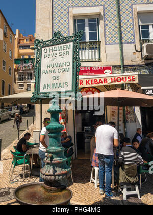 Portugal, Lissabon, Santa Apolonia Square, Rua Teixeira Lopes, Kunden am Bürgersteig Tische draußen Kebab Shop am Alten, Tier Wasser Brunnen Stockfoto