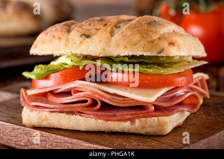 Eine köstliche deli Sandwich auf jalapeno Cheddar ciabatta Brot mit Salat und Tomate. Stockfoto