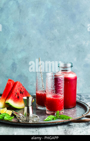 Frisch gepresster Saft von Wassermelonen auf einem Tisch in Gläser. Vorbereitung auf einen Cocktail oder ein alkoholfreies Getränk. Gesunde Ernährung und Fruitarianism Stockfoto