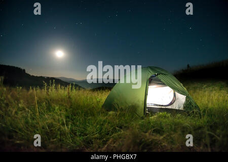 Grüne Zelt in den Bergen bei Nacht Stockfoto