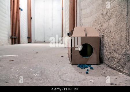 Ein Bild von einem Papier Ratte Trap mit einigen Pellets mit Gift außerhalb der Box. Gefährlich zu berühren oder zu essen. Stockfoto