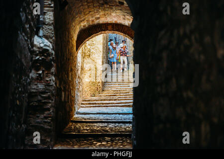 Girona, Spanien - 9. Juli 2018: Touristen an dunklen mittelalterlichen Passage mit Treppen im Jüdischen Viertel der Altstadt von Girona in Katalonien, Spanien Stockfoto