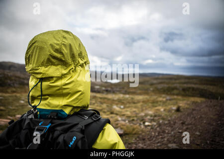 Frau im Regen mit Haube Stockfoto