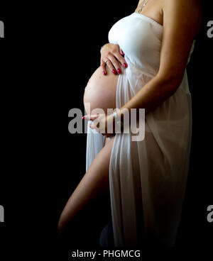 3/4 Seite proflie der schwangeren Frau mit Ihrem Babybauch mit schwarzem Boden zurück Stockfoto