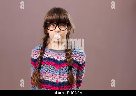 Wenig nerdy Mädchen bläst Bubble gum Stockfoto