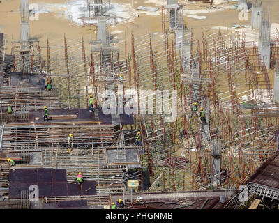 Ein Luftbild der Baustelle, wo in der Spalte aktiv auf der Platte für die nächste Stufe zur Verfügung gestellt wird. Arbeitnehmer arbeiten in Phasen. Stockfoto