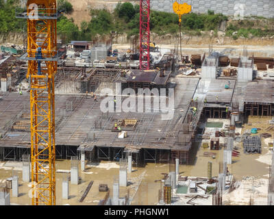 Ein Luftbild der Baustelle, wo in der Spalte aktiv auf der Platte für die nächste Stufe zur Verfügung gestellt wird. Arbeitnehmer arbeiten in Phasen. Stockfoto