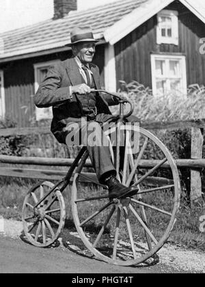 Penny Farthing Fahrrad. Ein Mann reitet einen penny-farthing Fahrrad hat er mit hölzernen Räder der Vorder- und Rückseite. Schweden 1940 Stockfoto