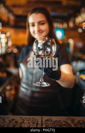 Weibliche Barkeeper Schürze hält ein Glas an der Bar. Barkeeper Beruf, bartending Stockfoto