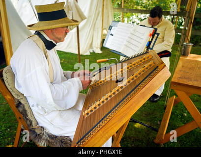 Männliche spielen Hackbrett, Britische Militär, Royal Nancy, amerikanischen militärischen Encampment reenactors Piraten, Voyageurs und Royal Navy Gun Wuchs Stockfoto