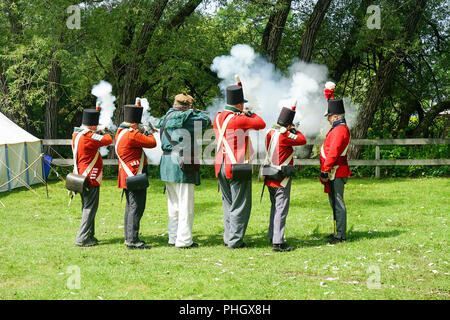 Muskete Demonstration in der Britischen Armee, der Royal Nancy, amerikanischen militärischen Encampment mit Reenactors mit Piraten, Voyageurs und Royal Navy Gun Wuchs Stockfoto