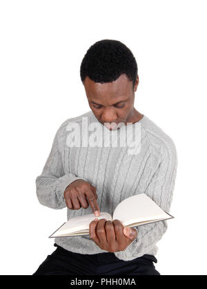 Afrikanische Mann sitzt und sein Buch lesen Stockfoto