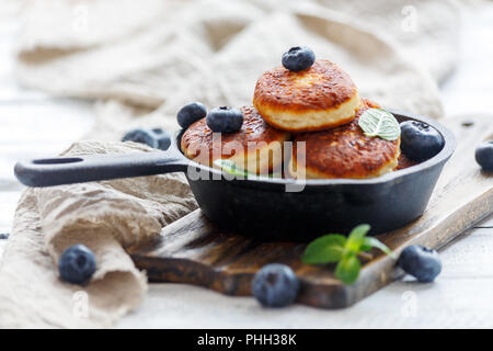 Käse Pfannkuchen und Blaubeeren in gusseisernen Pfanne. Stockfoto